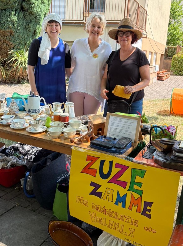 ZuzeZamme beim Flohmarkt mit einem Stand und dem ZuzeZamme-Schild